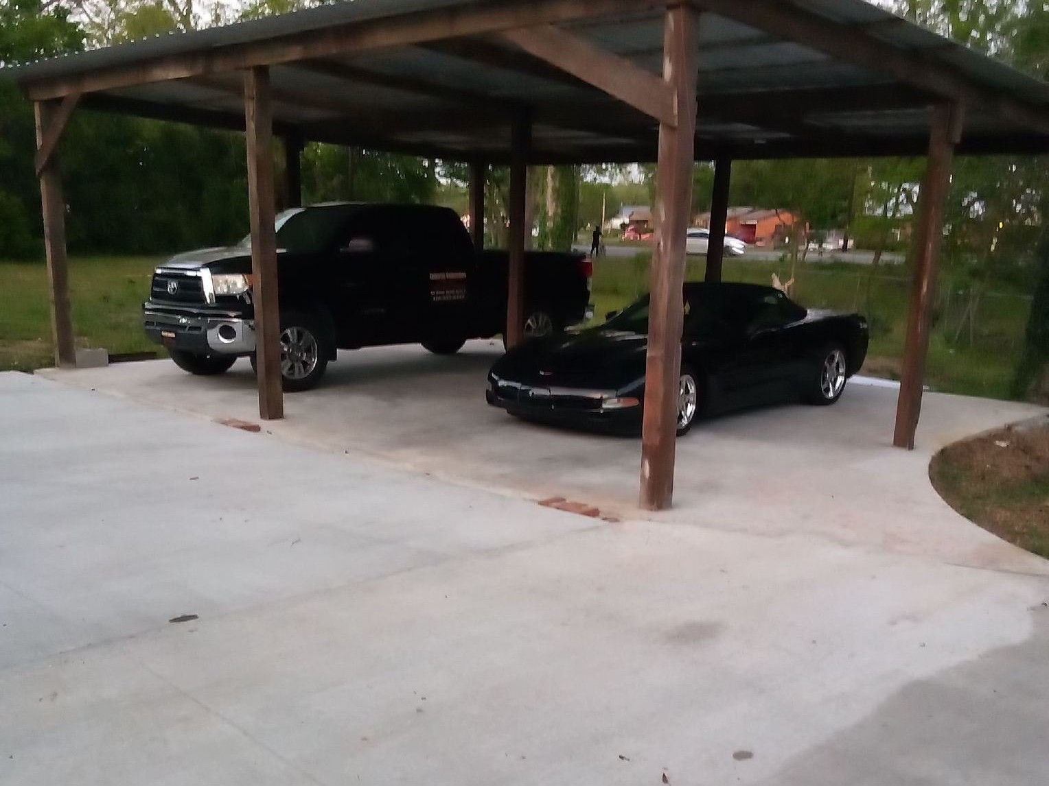 Monolithic carport and vehicle slab poured beneath timber roof by Willie Jackson